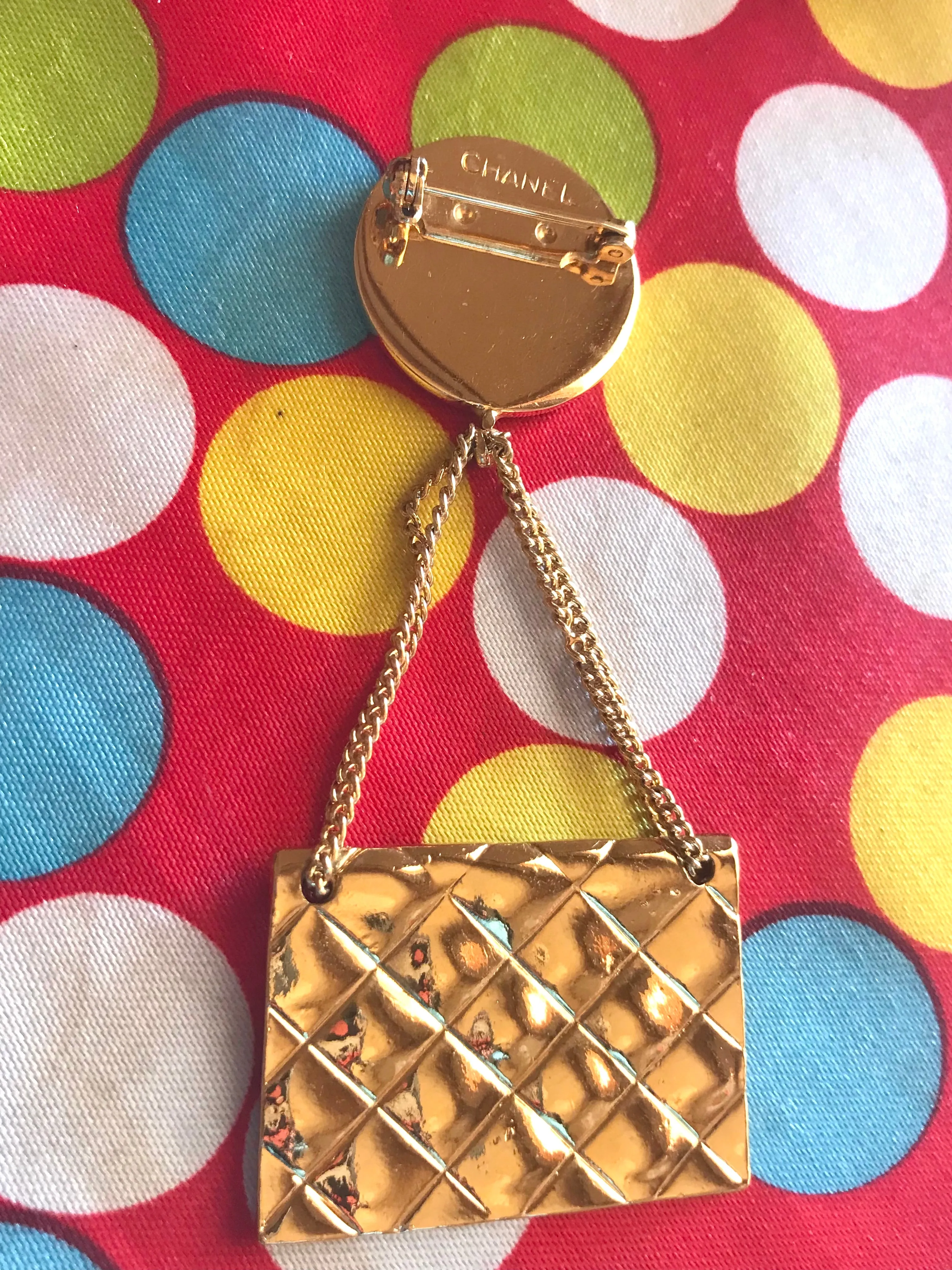 Vintage CHANEL Gold tone brooch with 2.55 classic purse and CC charms. Chic dangling brooch